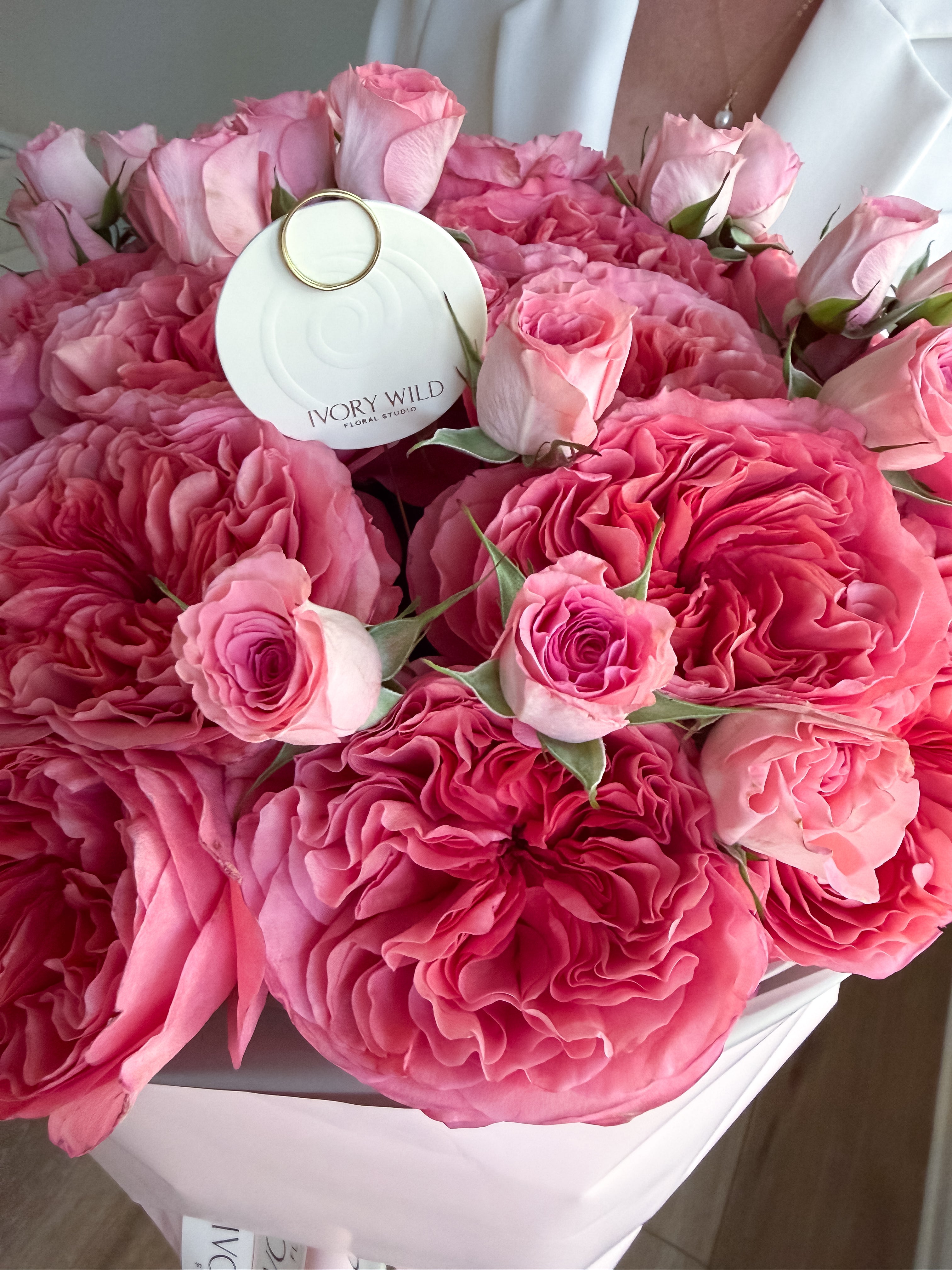 Ruffled deep pink garden rose petals contrast with smaller pale pink spray roses.